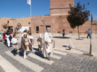 Estandartes, autoridades y participantes en un desfile hacia el castillo pilas bonas de Manzanares