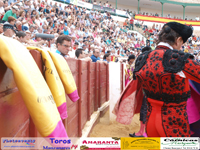Fotografia desde la arena del tendido en plaza de toros de Manzanares, vista general del público y con capotes sobre las tablas.